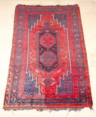 A blue and red ground Kurdish rug with lozenge shaped medallion to the centre 97" x 63", in wear
