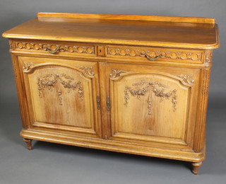 A 19th Century carved walnut side cabinet with raised back, fitted 2 long drawers above a double cupboard enclosed by arched panelled doors with fluted columns to the sides, raised on turned supports 41"h x 58"w x 22 1/2"d 