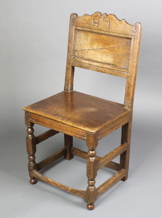 A 17th/18th Century oak chair of joined construction and solid seat, the arched back marked H L I, raised on turned and block supports with box framed stretcher, raised on bun feet (possibly replacements) 

