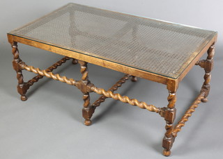 A 17th Century style rectangular oak occasional table with plate glass top, raised on spiral turned supports with box stretcher and woven cane panelled top 19" x 42" x 24"