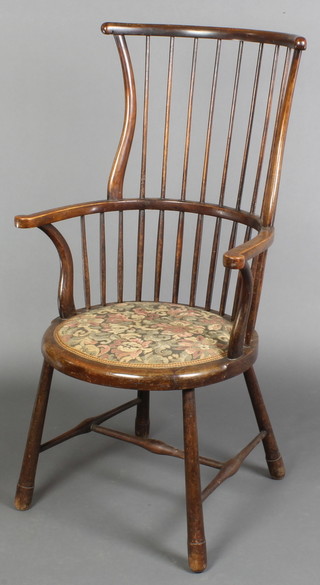 An Edwardian stick and rail back carver chair with upholstered seat on turned supports and H framed stretcher (f), the base with paper label marked Pudders of Whitstable 