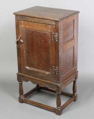 A 17th/18th Century style oak pot/side cabinet fitted a panelled with door with iron H framed hinges, raised on turned and block supports 34"h x 18"w x 13"d 