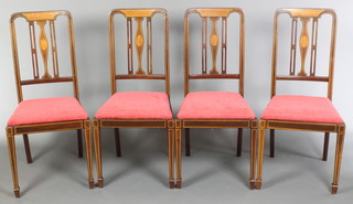 A set of 4 Edwardian inlaid mahogany stick and rail back dining chairs with upholstered drop in seats, raised on square tapering supports spade feet 