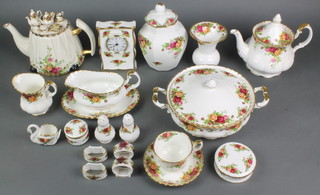 A Royal Albert Old Country Roses tea and dinner service comprising a teapot and lid, 8 tea cups, 6 saucers, 2 tier cake stand, milk jug and sugar bowl, 6 small dessert bowls, 6 large dessert bowls, 7 small plates, 7 medium plates, 6 dinner plates, 2 tureens and covers, 2 oval serving dishes, 4 odd dishes, 2 condiments, a lidded jar and cover, timepiece 8 napkin rings, a baluster vase, a swan vase, ashtray, 3 lidded boxes, a teapot with fancy lid, a sauce boat and stand, a pickle fork, a lid, 3 odd saucers, a wall timepiece, a tea cup stand, 2 meat plates, a set of table mats, a tray, 6 place mats and coasters 