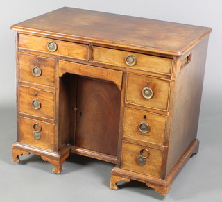 A Georgian mahogany kneehole pedestal dressing table fitted 2 long drawers, the pedestal fitted a drawer above a cupboard enclosed by panelled doors flanked by 6 short drawers, raised on bracket feet 31"h x 36"w  x 23"d  