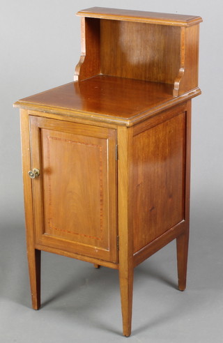 A Victorian inlaid mahogany bedside cabinet with raised back, fitted a cupboard enclosed by a panelled door, raised on square tapering supports 36"h x 16"w x 17 1/2"d
