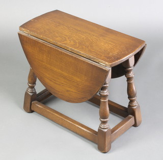 An oval oak drop flap occasional table, raised on turned and block supports 17"h x 21"w x 9 1/2" when closed by 29" when extended 