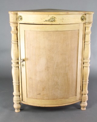 A 19th/20th Century pine bow front corner cabinet enclosed by panelled doors with turned columns to the sides with gilt metal embellishments 37"h x 28 1/2"w x 19"d   