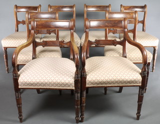 A set of 8 Regency bar back dining chairs with shaped mid rails and upholstered seats, raised on turned supports comprising 2 carvers, 6 standard 