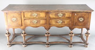 A Queen Anne style figured walnut dresser base, the crossbanded top fitted 4 short drawers flanked by a pair of cupboards and raised on 7 cup and cover supports with wavy stretcher and bun feet 33"h x 75"w x 23 1/2"d 