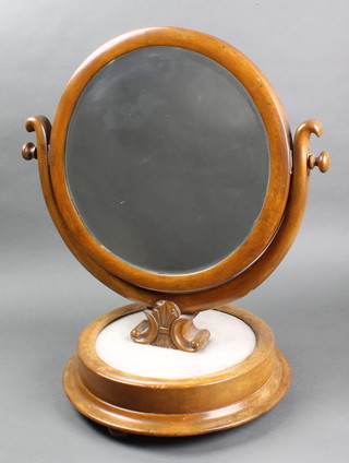 A Victorian circular bevelled plate dressing table mirror contained in a mahogany swing frame, raised on a circular marble and mahogany base 24"h x 19"w x 14"