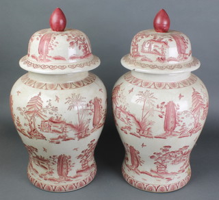 A pair of 20th Century Chinese baluster vases and covers the ochre decoration with extensive landscape scenes and birds with domed lids, similarly decorated 21"