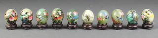 10 turned green hardstone models of eggs with floral decoration and complete with stands 