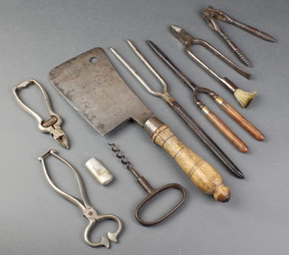 A metal cleaver with turned wooden handle, a pair of metal sugar cutters, a 19th Century polished steel corkscrew, a Tonley champagne wire cutter? 2 pairs of curling tongs, etc 