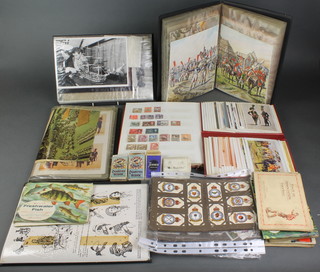 A stock book of various world stamps, an album of various military postcards and a collection of loose cigarette cards and stamps 
