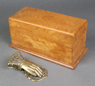 A Victorian brass paperclip in the form of a ladies hand 5 1/2" x 2 1/2" and a rectangular oak trinket box on a shaped base 4 1/2"h x 9 1/2"w x 4 1/2"d 