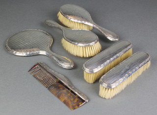 A silver engine turned 6 piece brush set with monogram, comprising hand mirror, 2 hair brushes, 2 clothes brushes and  a comb, Birmingham 1911/13/16 