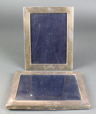 A modern rectangular silver photograph frame 9" x 7", a ditto 9" x 7", 1 engraved with an inscription 