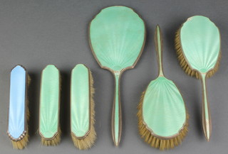 A silver and green guilloche enamel dressing table set comprising hand mirror, 2 clothes brushes and 2 hair brushes Birmingham 1936, together with a silver and blue guilloche enamel clothes brush