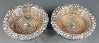 A near pair of Georgian silver coasters with shell and scroll decoration, the centre set with a chased armorial, Sheffield 1825 and 1828, 6 3/4" 