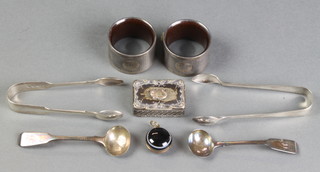 A Continental 900 repousse pill box with scroll decoration 2" x 1 1/4", 2 napkin rings, 2 pairs of nips, 2 spoons and a pendant 