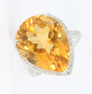 A 14ct white gold citrine and diamond ring, the centre stone approx 13cts flanked by diamonds approx 0.5ct, size M 1/2