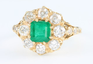 A 15ct yellow gold emerald and diamond cluster ring, the centre square shaped stone flanked by 8 brilliant cut diamonds, size L 1/2