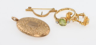 A 9ct yellow gold peridot and seed pearl ring size L, a 9ct gold locket, a scarf pin and a pair of earrings 