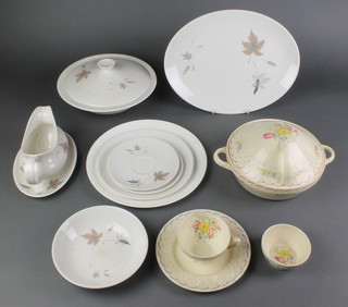 A quantity of Royal Doulton Tumbling Leaves dinner ware comprising 7 dessert bowls, 13 side plates, 5 dinner plates, 2 tureens and covers, 10 saucers, 8 small plates, sauce boat and stand and a serving dish together with a Susie Cooper part dinner service comprising 2 tureens and lids, a sugar bowl, tea cup and side plated 