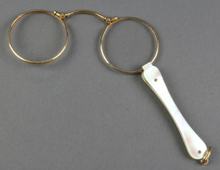 A pair of gilt pince nez with mother of pearl handle