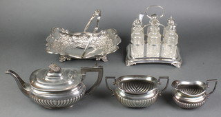 An Edwardian silver plated 6 bottle condiment stand with cut glass bottles and plated mounts, a 3 piece tea set and a repousse swing handled basket