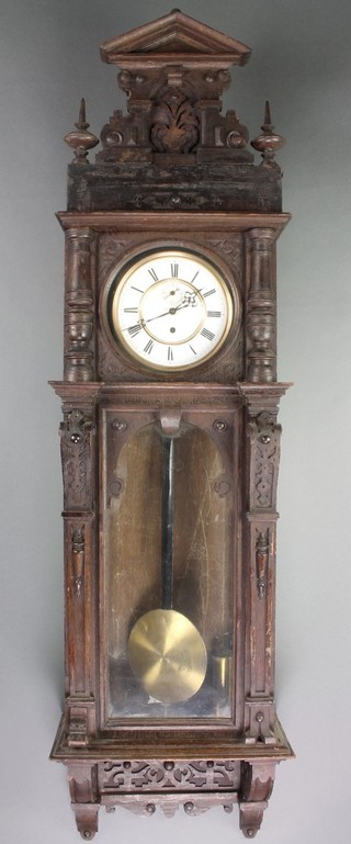 A Vienna style regulator with 7" dial and Roman numerals contained in a carved oak case 