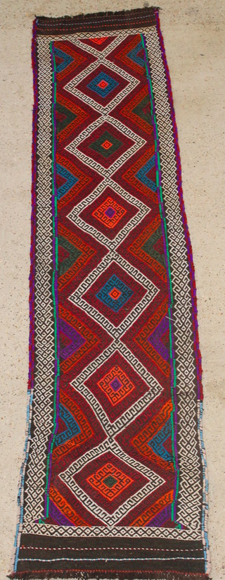 A Persian multi coloured Kilim runner with 6 diamond medallions to the centre 113" x 26" 