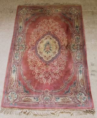 A pink and floral patterned Chinese carpet with central medallion 109" x 70", some staining 