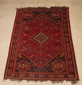 A Persian red ground rug with central medallion 98" x 71", some wear 