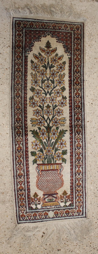 A white ground Persian silk runner, the centre decorated a vase of flowers within a mihrab 42" x 15 1/2" 