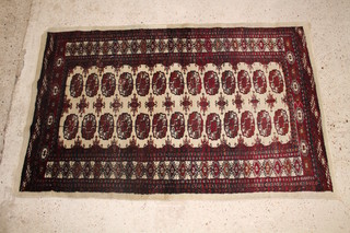 A white ground Bokhara rug with 26 octagons to the centre, in wear 58" x 36"  