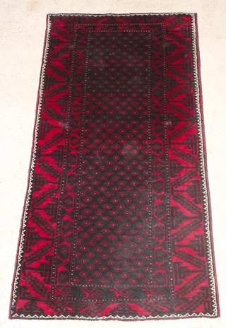 A red and black Afghan rug with all-over geometric design 88" x 42" 