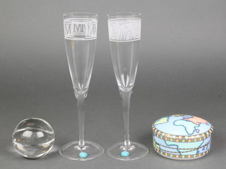A Tiffany & Co spherical clear glass faceted paperweight, boxed, a pair of ditto champagne flutes boxed and a circular porcelain box, boxed 