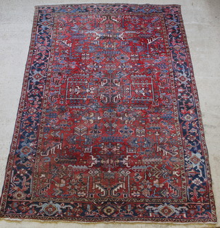 A Persian red and blue ground Heriz carpet 130" x 88" 
