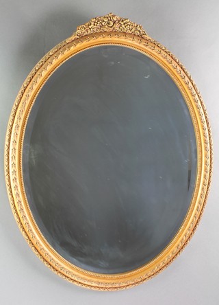 An oval bevelled plate wall mirror contained in a decorative gilt frame 28" x 22" 