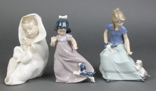 A Nao figure of a child wrapped in a blanket 6 1/2", a ditto of a girl with puppy 6", a ditto of a young lady with puppies 7" 