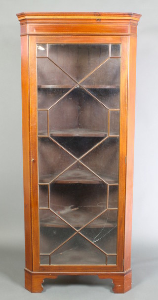 An Edwardian inlaid mahogany corner cabinet with moulded cornice, the interior fitted shelves enclosed by astragal glazed panelled doors, raised on bracket feet 70"h x 29 1/2"w x 17"d 