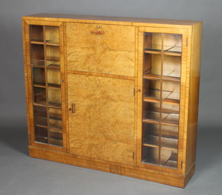 An Art Deco figured walnut student's bureau bookcase with quarter veneered top, the fall front revealing a fitted interior above a cupboard, flanked by glazed panelled doors 42"h x 48"w x 10"d 