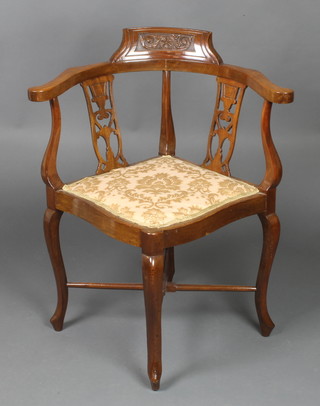 A Victorian carved walnut corner chair with pierced slat backs, raised on cabriole supports with X framed stretcher