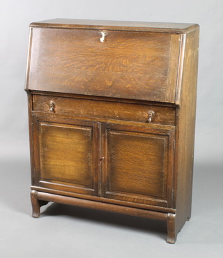 An oak Globe Wernicke bureau with fall front above 1 long drawer, the base fitted a cupboard enclosed by a panelled door 44"h x 34"w x 14 1/2"d 