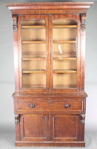 A Victorian mahogany secretaire bookcase, the upper section with moulded cornice, fitted adjustable shelves enclosed by arched panelled doors with vitruvian scrolls to the side, the base fitted a secretaire drawer above a cupboard enclosed by panelled doors 93"h x 48"w x 19"d  