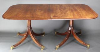 A Georgian style mahogany twin pillar dining table with 1 extra leaf and  brass inlay, raised on pillar and tripod supports 30"h x 41 1/2"w x 72"l , with extra leaf x 98"l 