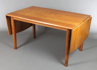 A 1960's rectangular teak drop flap dining table, raised on turned supports 29"h x 52 1/2" when closed x 85"l when fully extended by 32"w  