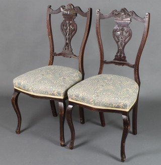 A pair of late Victorian salon chairs with pierced vase shaped slat backs and seats of serpentine outline, raised on cabriole supports 